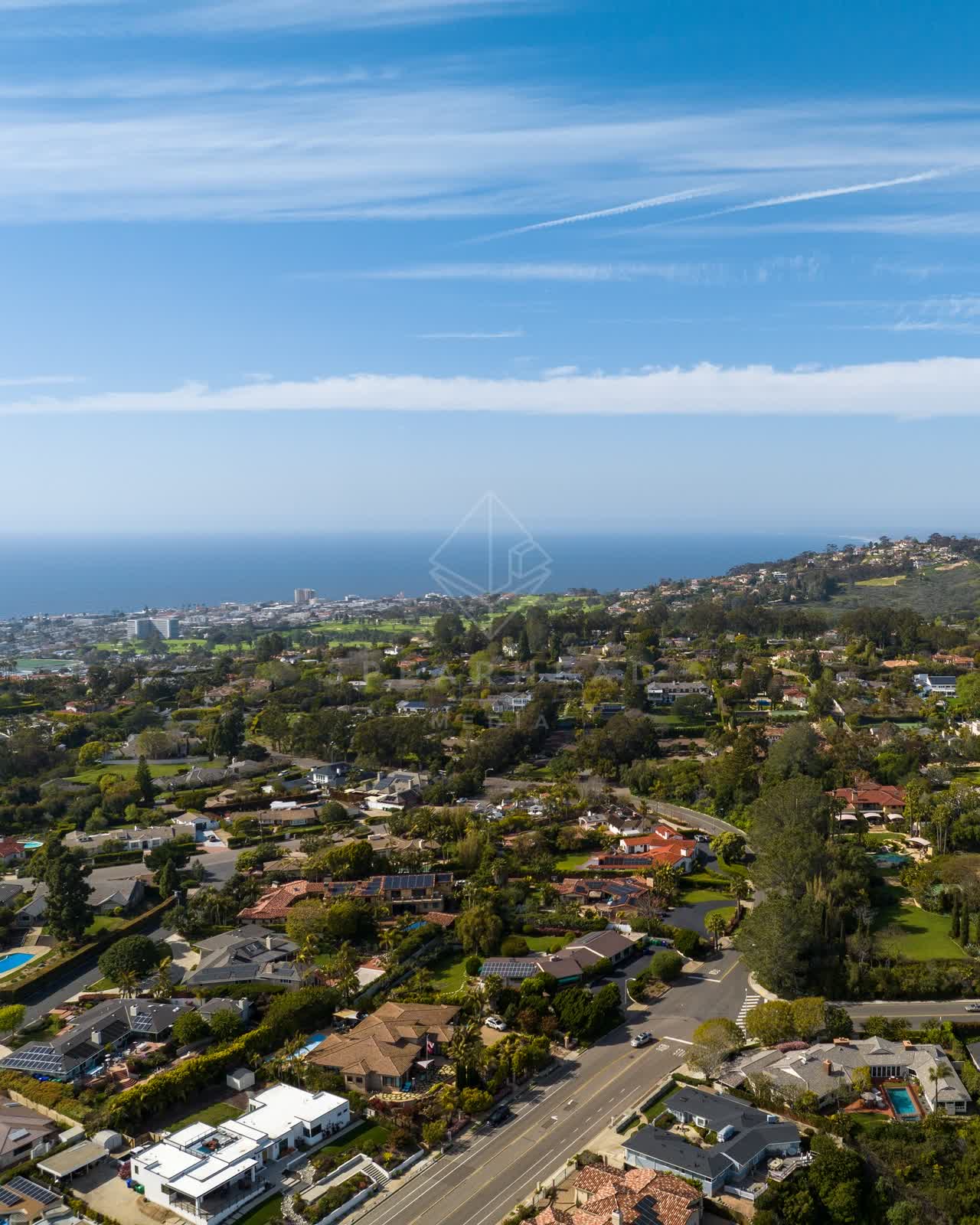 Aerial view of a residential street, the ocean and homes at La Jolla Mesa.