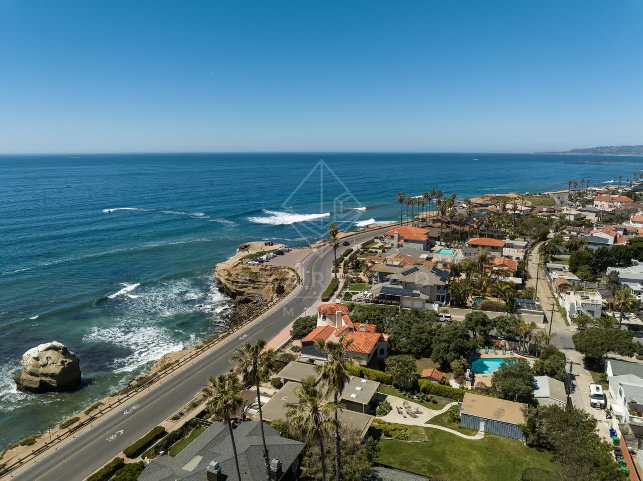 Aerial view of the cliffs, the surf and palm trees at Sunset Cliffs.
