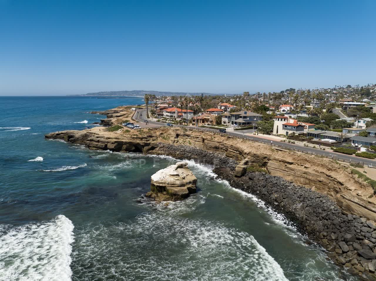 Aerial view of the cliffs, the surf and palm trees at Sunset Cliffs.