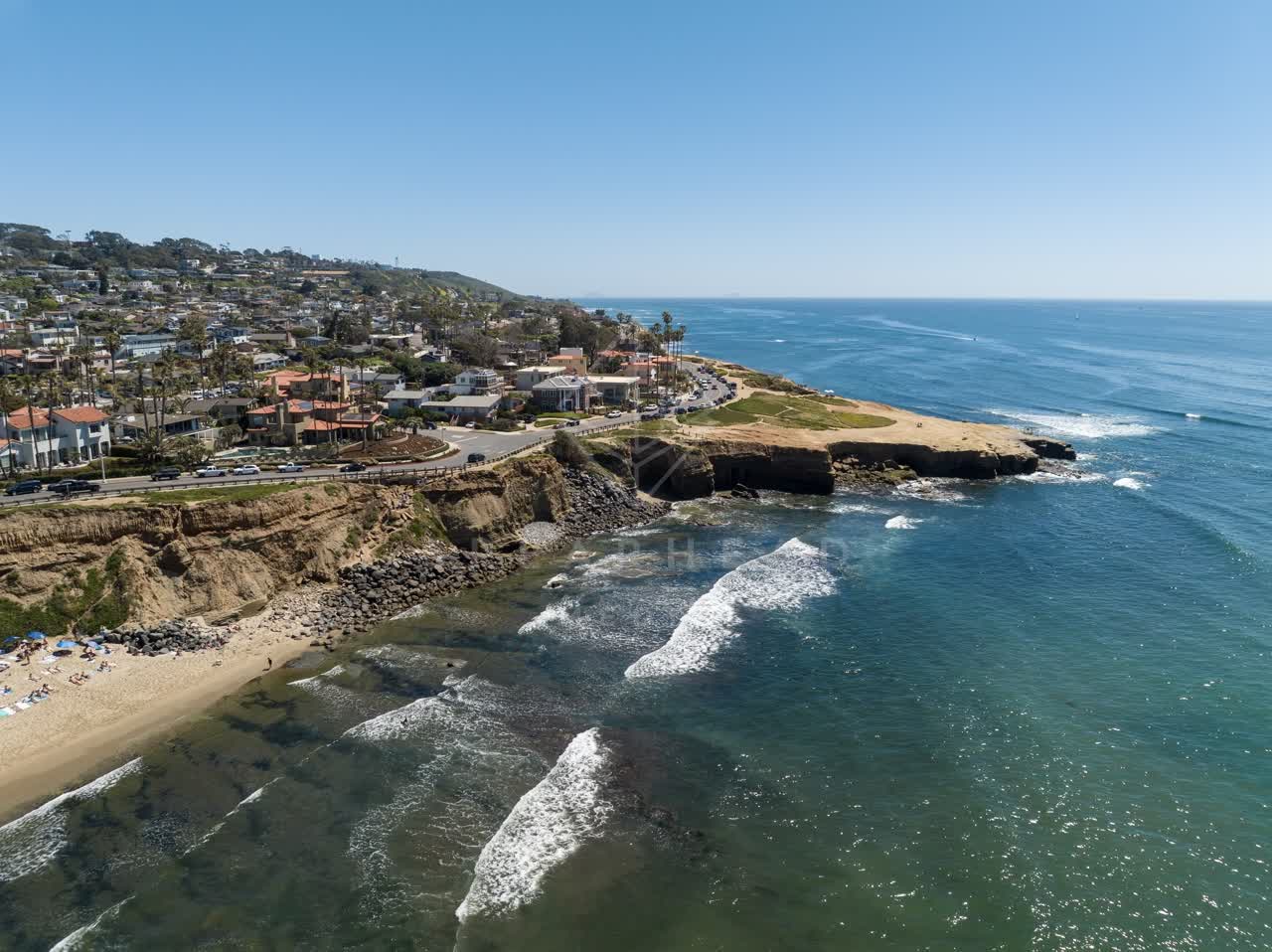 Aerial view of the cliffs, the surf and palm trees at Sunset Cliffs.