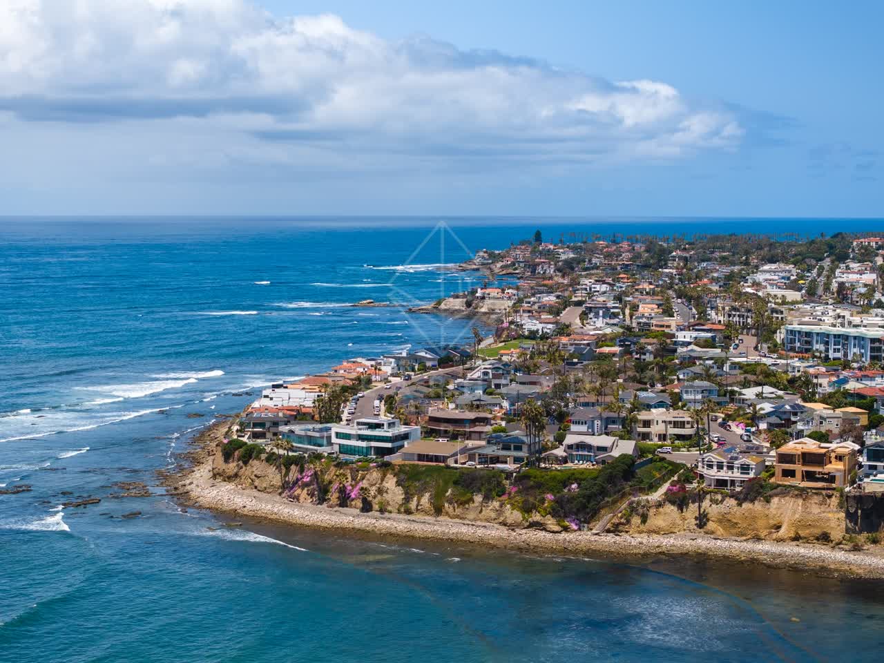 Aerial view of the cliffs, the surf and palm trees at Bird Rock.