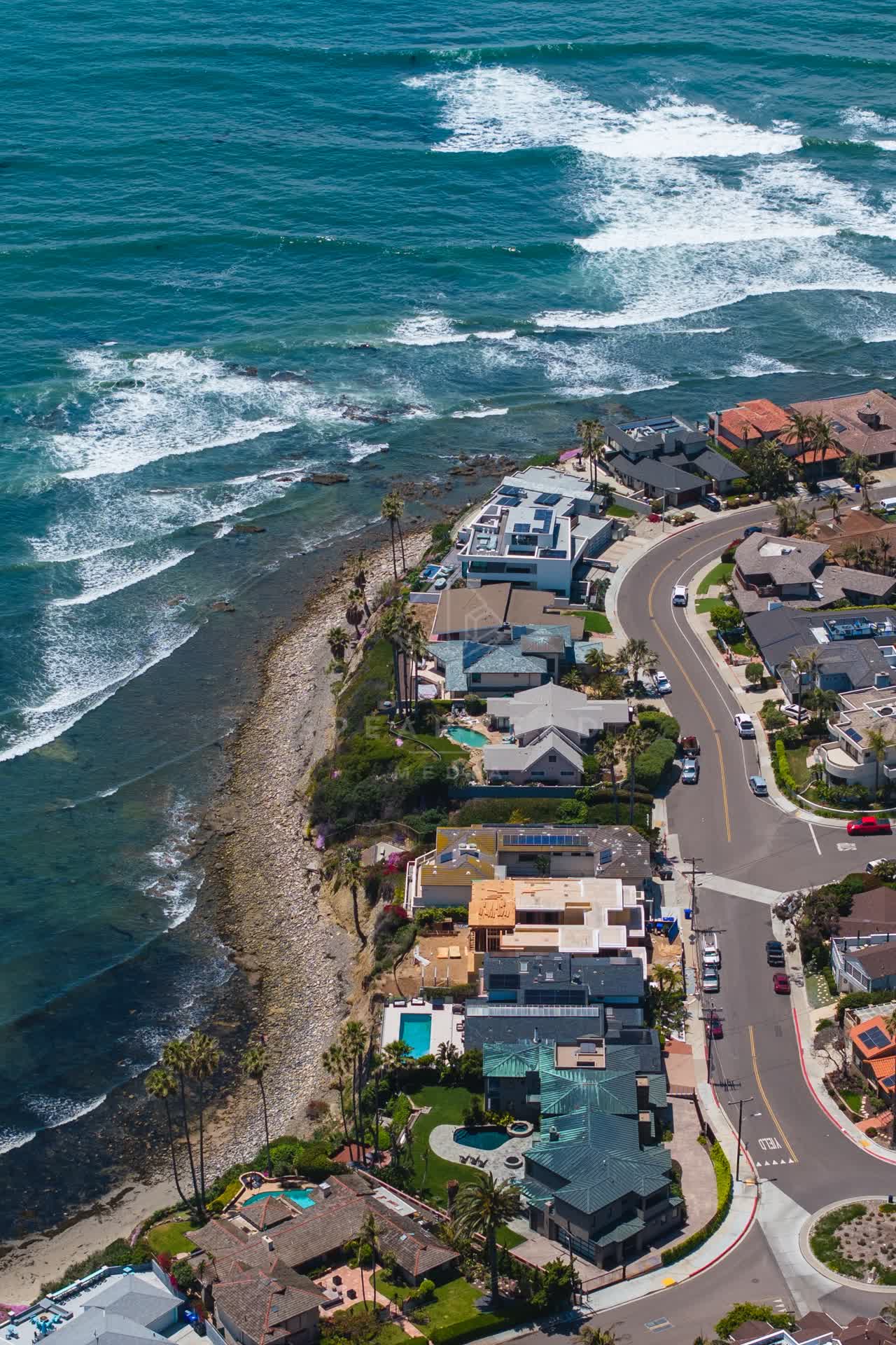 Aerial view of a residential street, the surf and palm trees at Bird Rock.