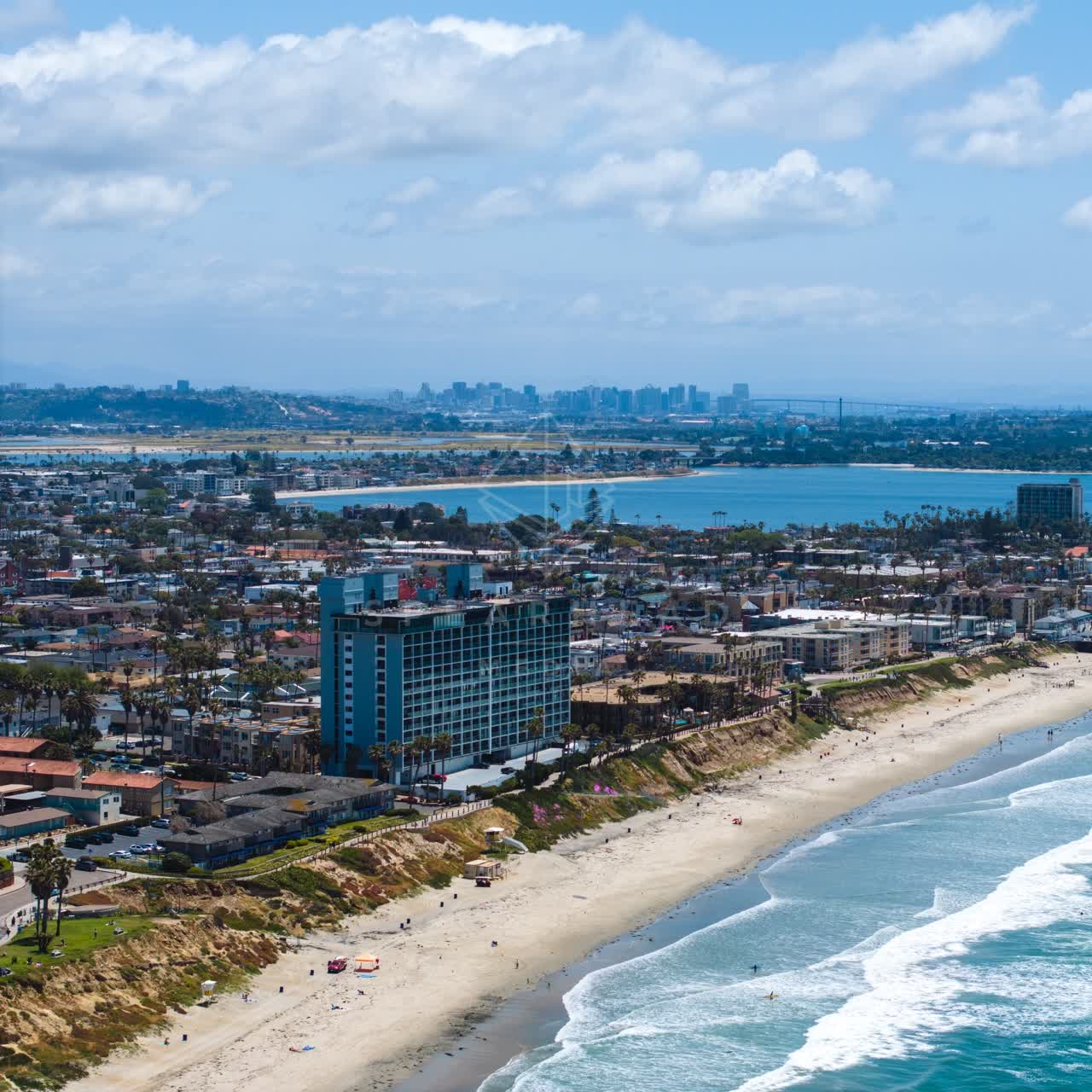 Aerial view of the beach, the surf and the skyline at Tourmaline, with people walking.
