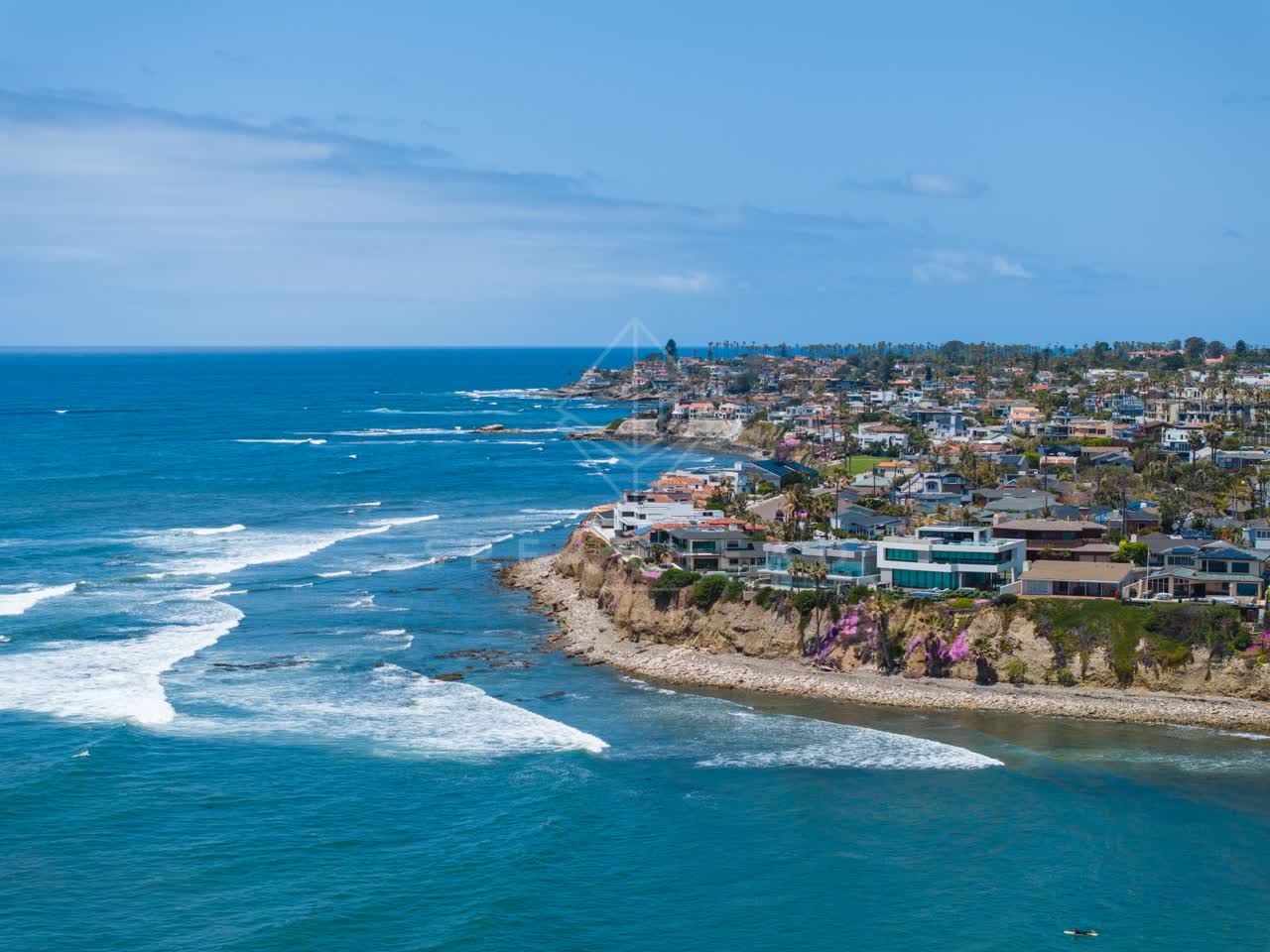 Aerial view of the cliffs, the surf and palm trees at Bird Rock.