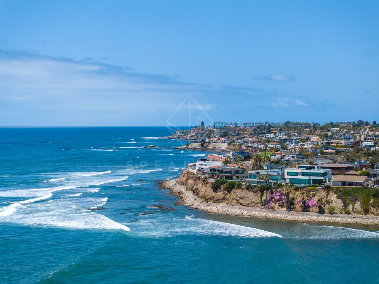 Aerial view of the cliffs, the surf and palm trees at Bird Rock.