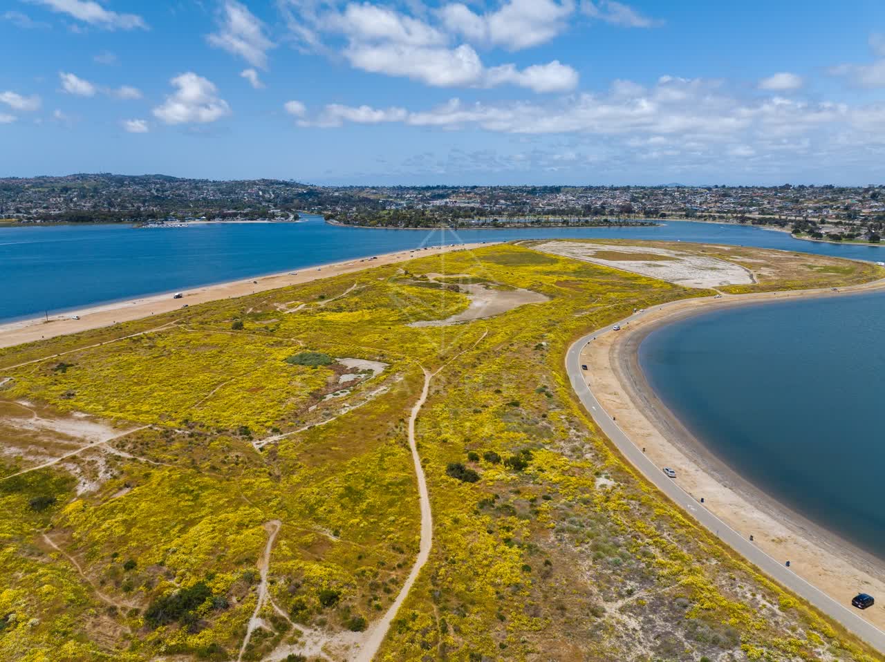 Aerial view of the beach, the bay and traffic in Mission Bay, with people walking.