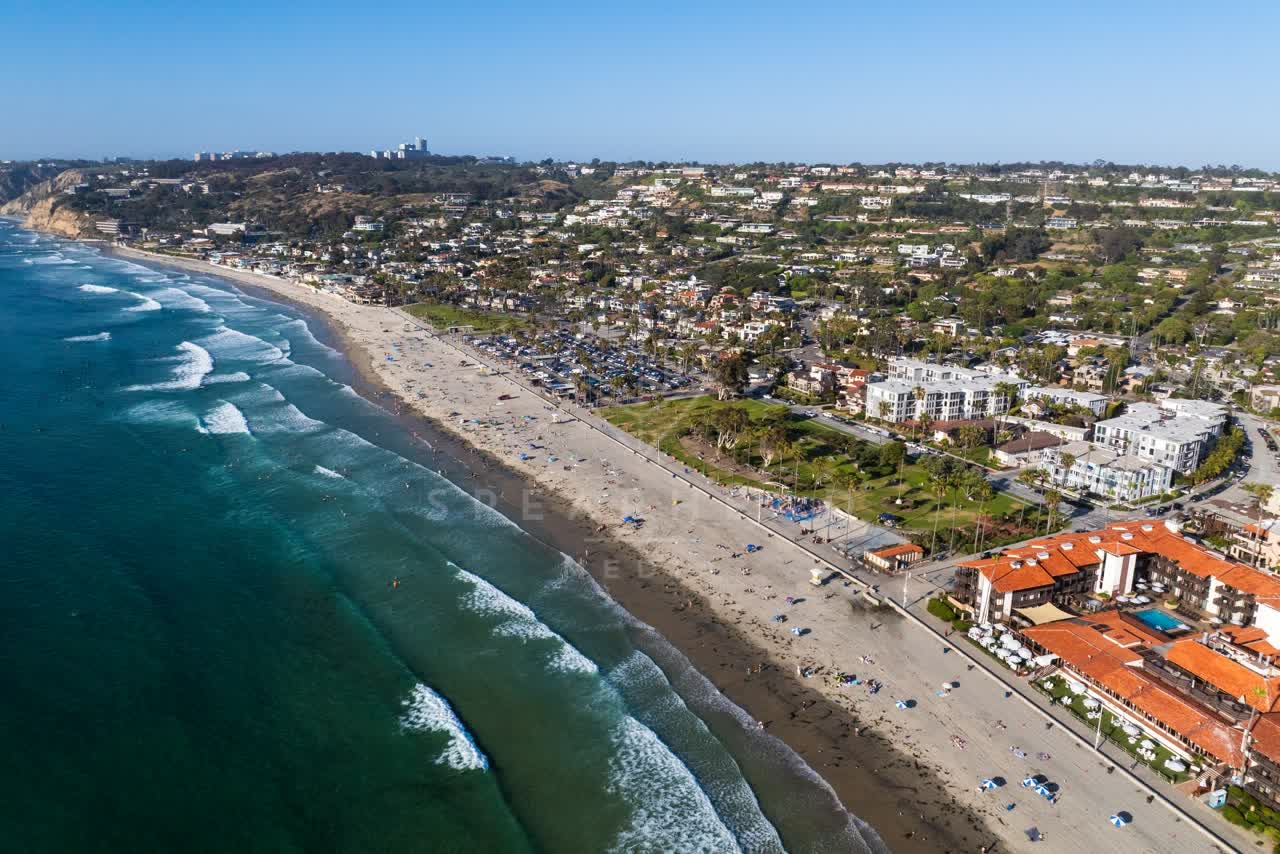 Aerial view of the beach, the surf and palm trees at La Jolla Shores, with people walking.