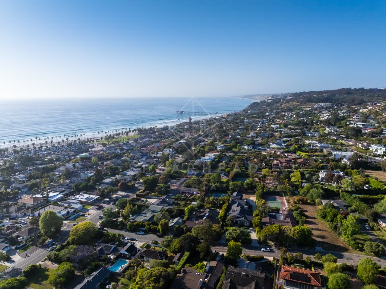 Aerial view of a residential street, the pier and palm trees at La Jolla Shores.