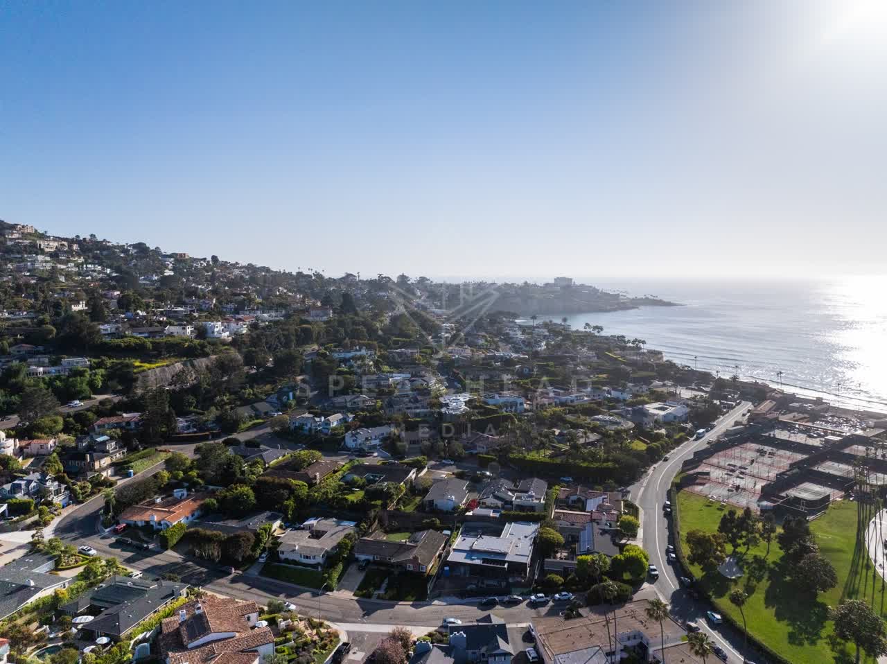 Aerial view of a residential street, the ocean and homes at La Jolla Shores.