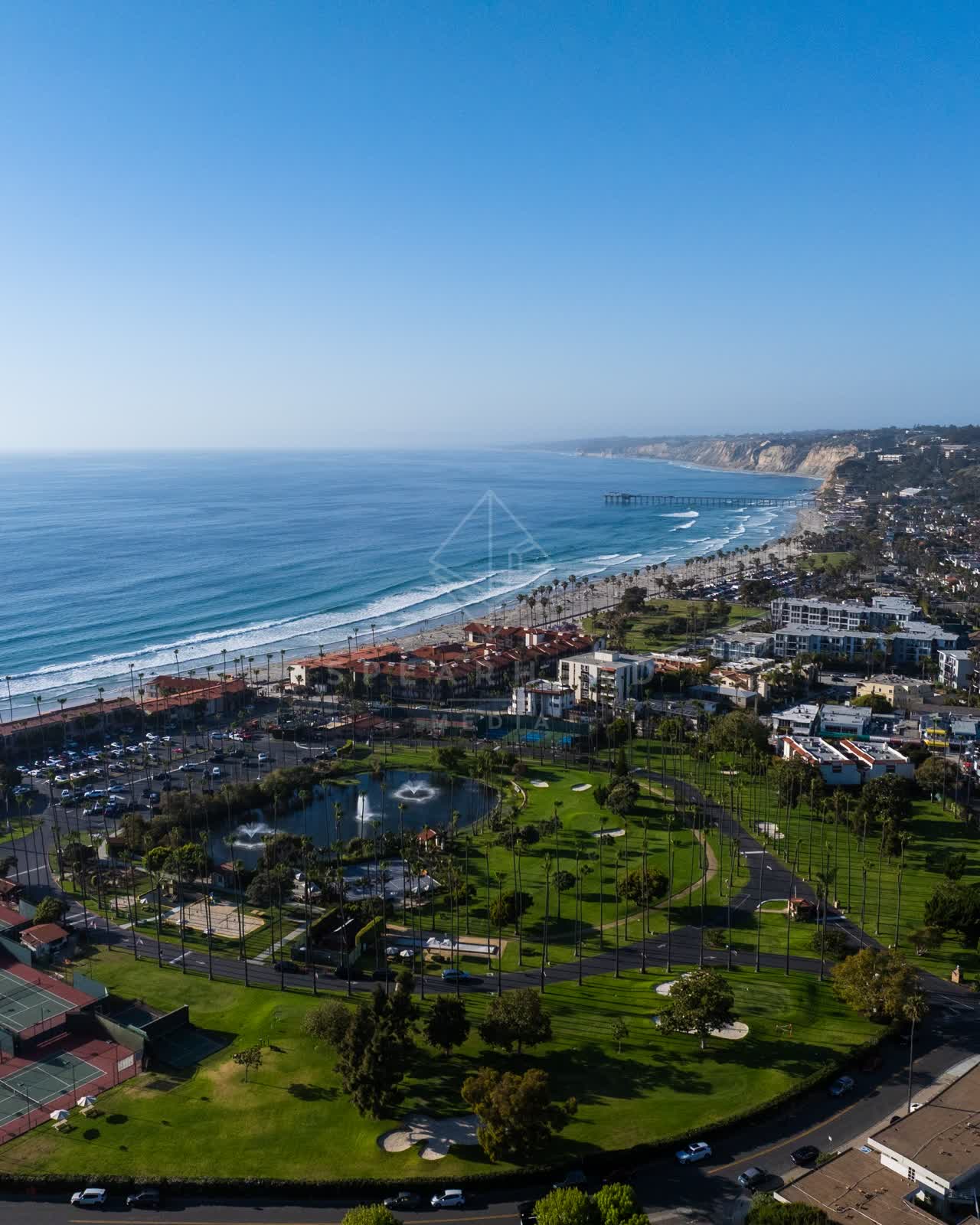 Aerial view of the beach, the pier and palm trees at La Jolla Shores.