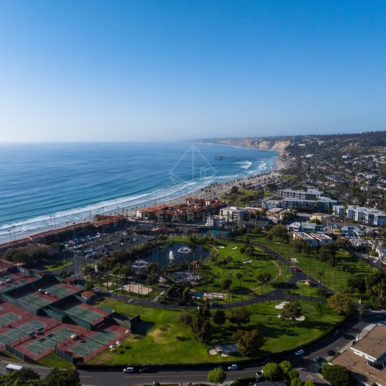 Aerial view of a residential street, the pier and palm trees at La Jolla Shores.