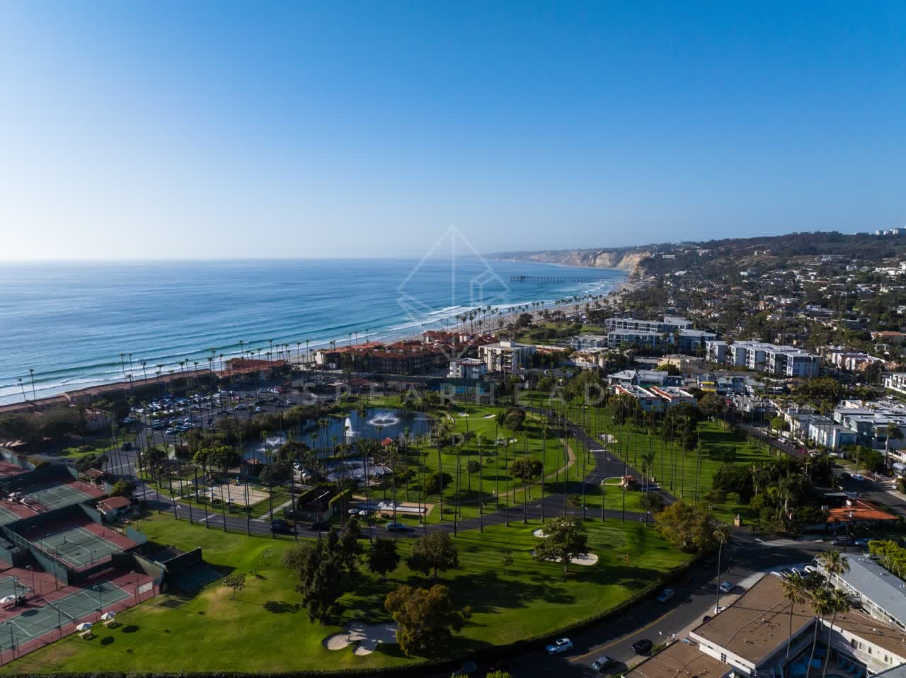 Aerial view of a residential street, the pier and palm trees at La Jolla Shores.