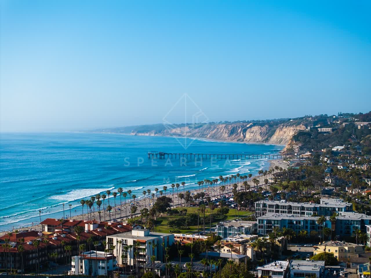 Aerial view of the beach, the pier and palm trees at La Jolla Shores.