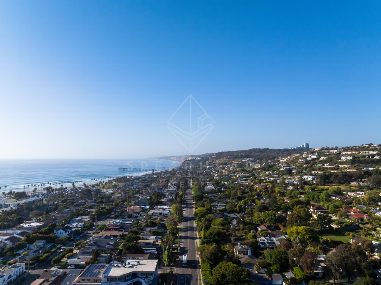 Aerial view of a residential street, the pier and palm trees at La Jolla Shores.