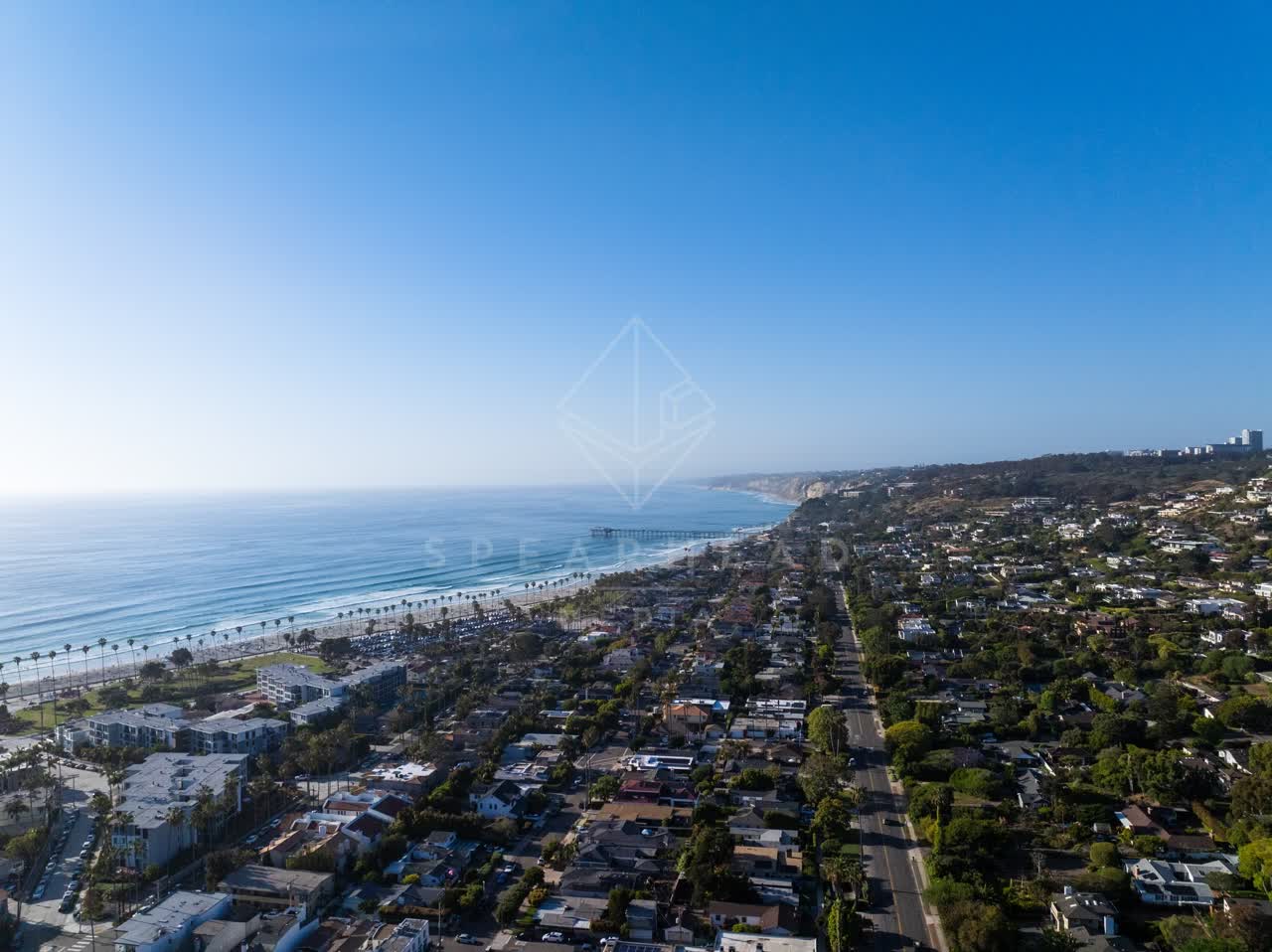 Aerial view of a residential street, the pier and palm trees at La Jolla Shores.