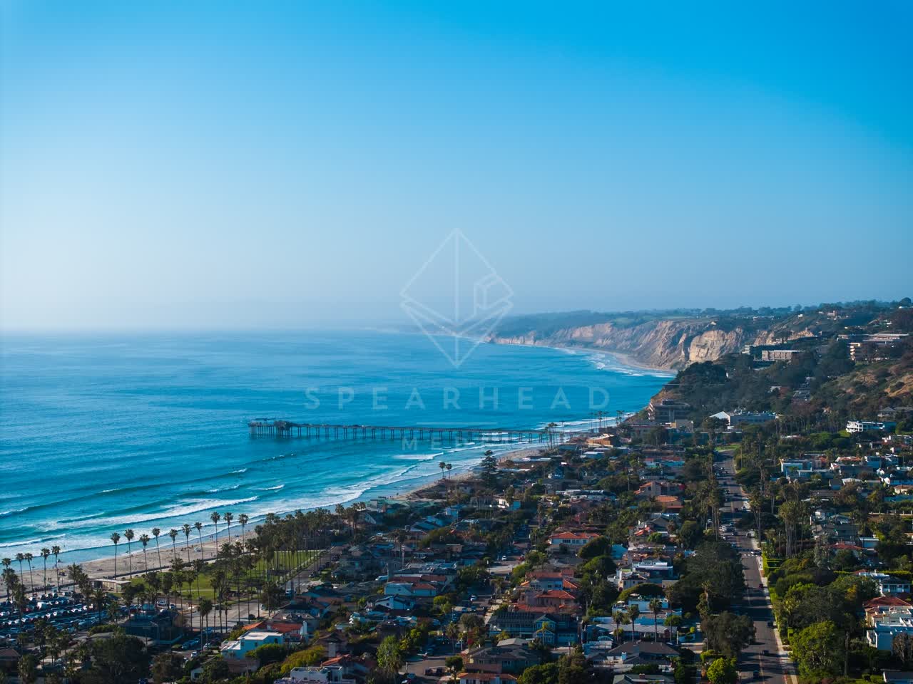 Aerial view of the beach, the pier and palm trees at La Jolla Shores.
