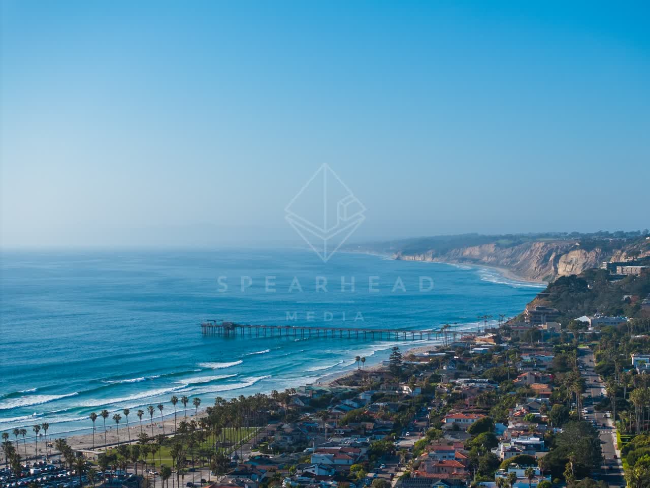 Aerial view of the beach, the surf and the pier at La Jolla Shores.