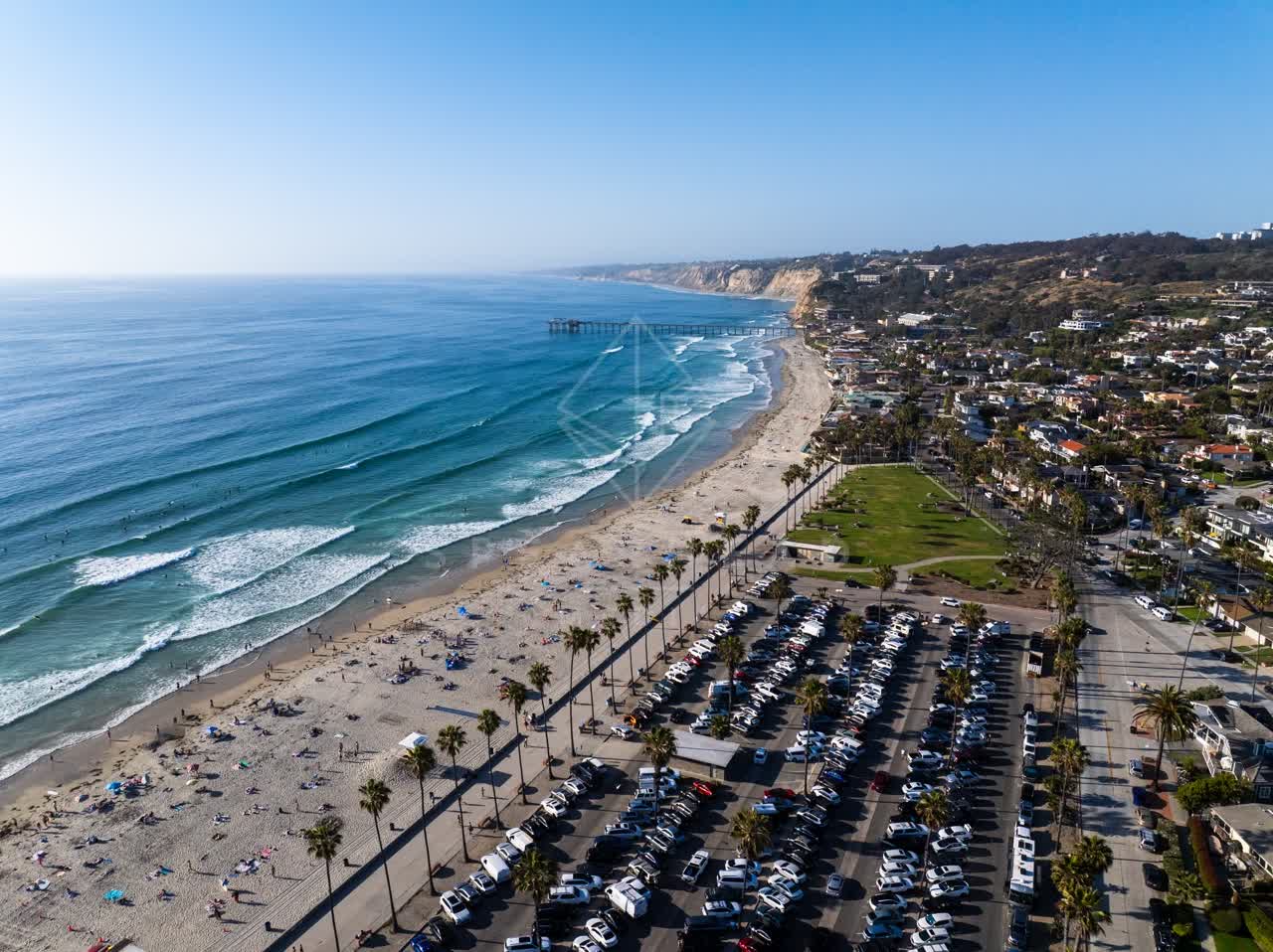 Aerial view of the beach, the surf and the pier at La Jolla Shores, with people walking.