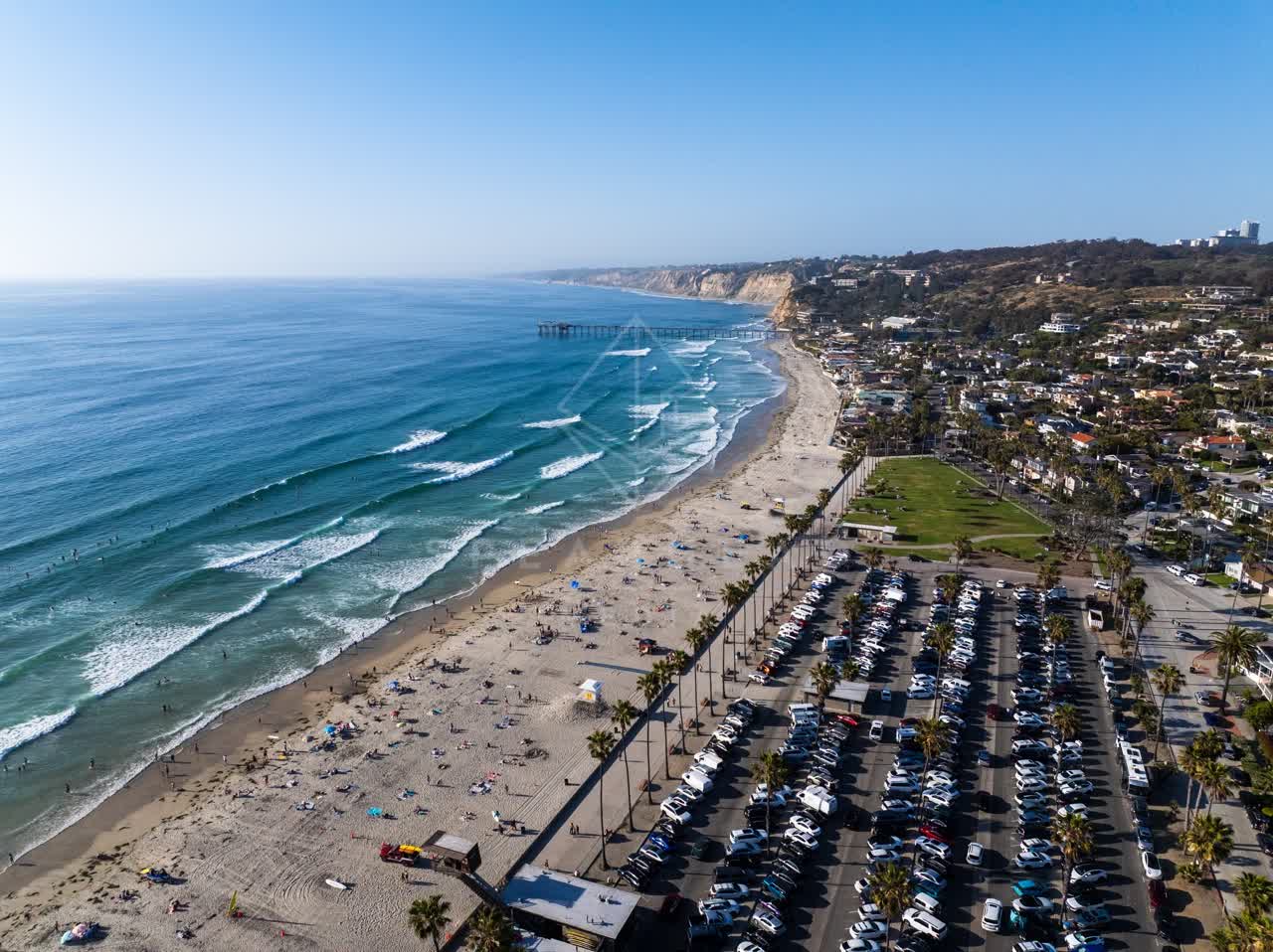 Aerial view of the beach, the surf and the pier at La Jolla Shores, with people walking.