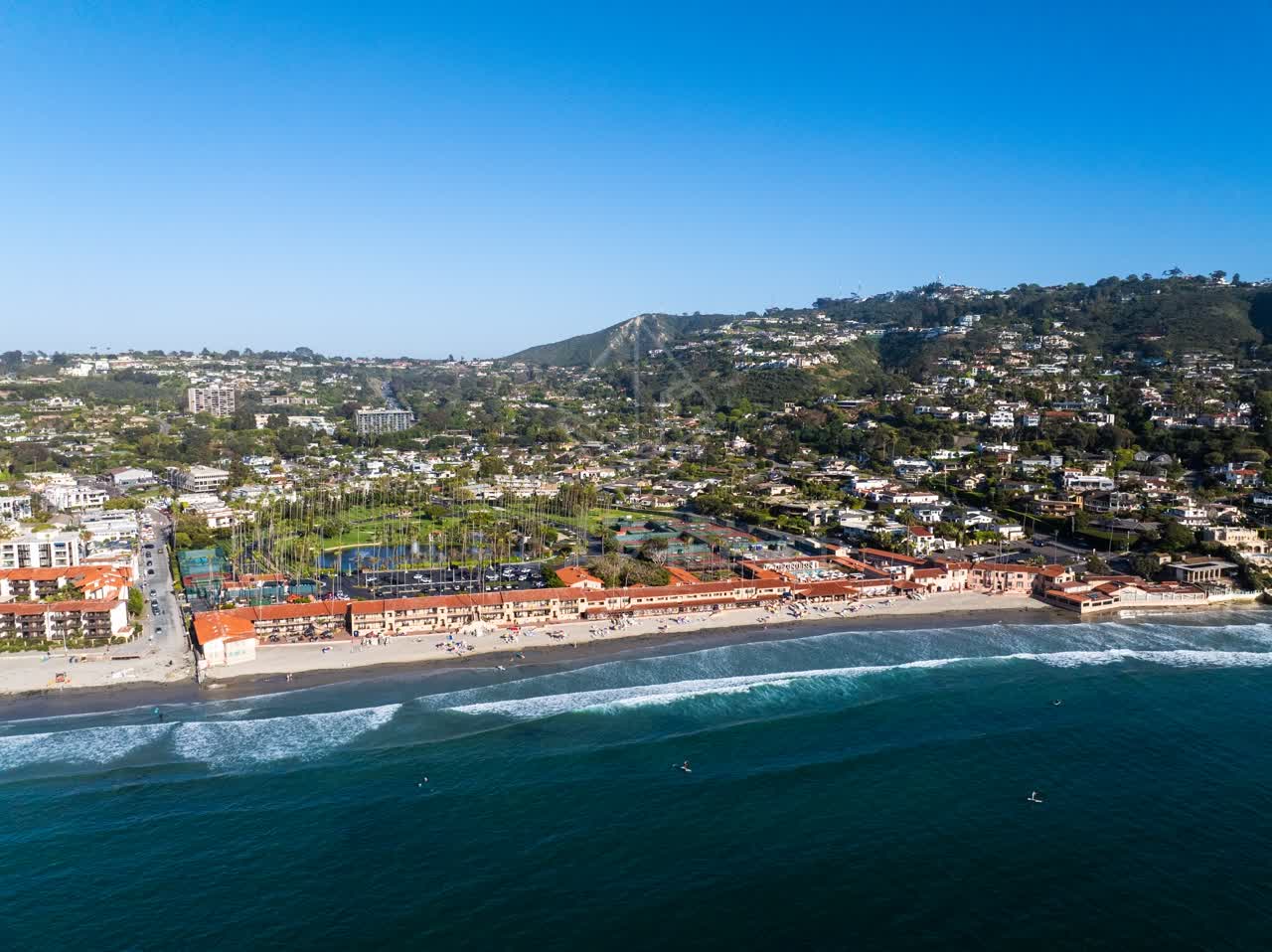 Aerial view of the beach, the surf and palm trees at La Jolla Shores, with people walking.