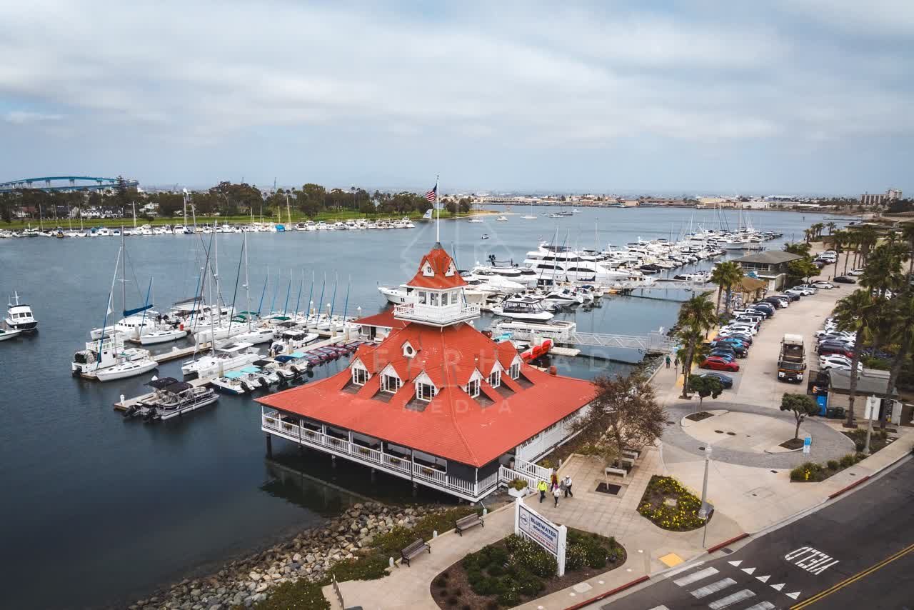 Aerial view of the harbor, the bridge and boats at Coronado Beach, with people walking.