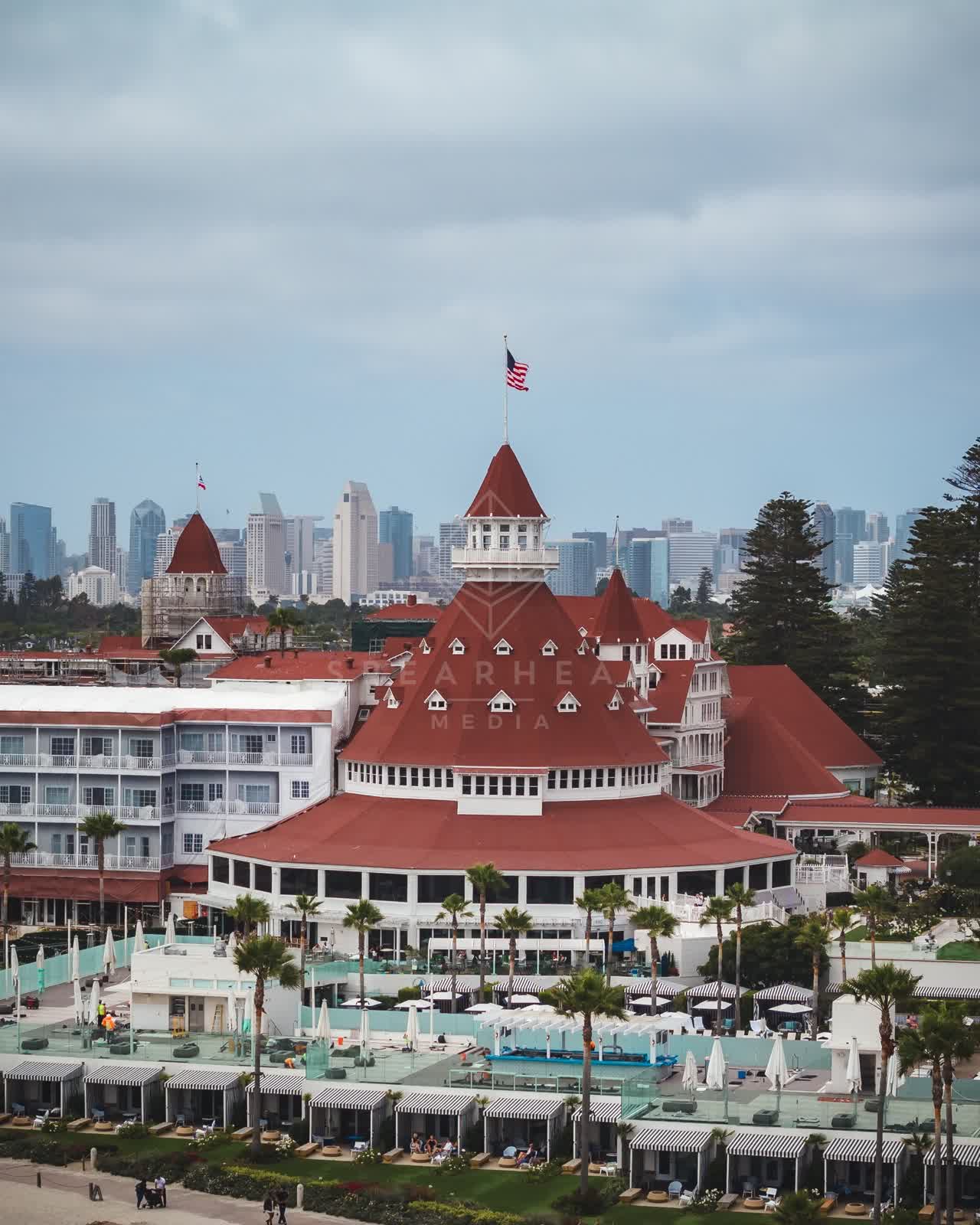 Low aerial view of the beach, the skyline and palm trees at Coronado Beach.