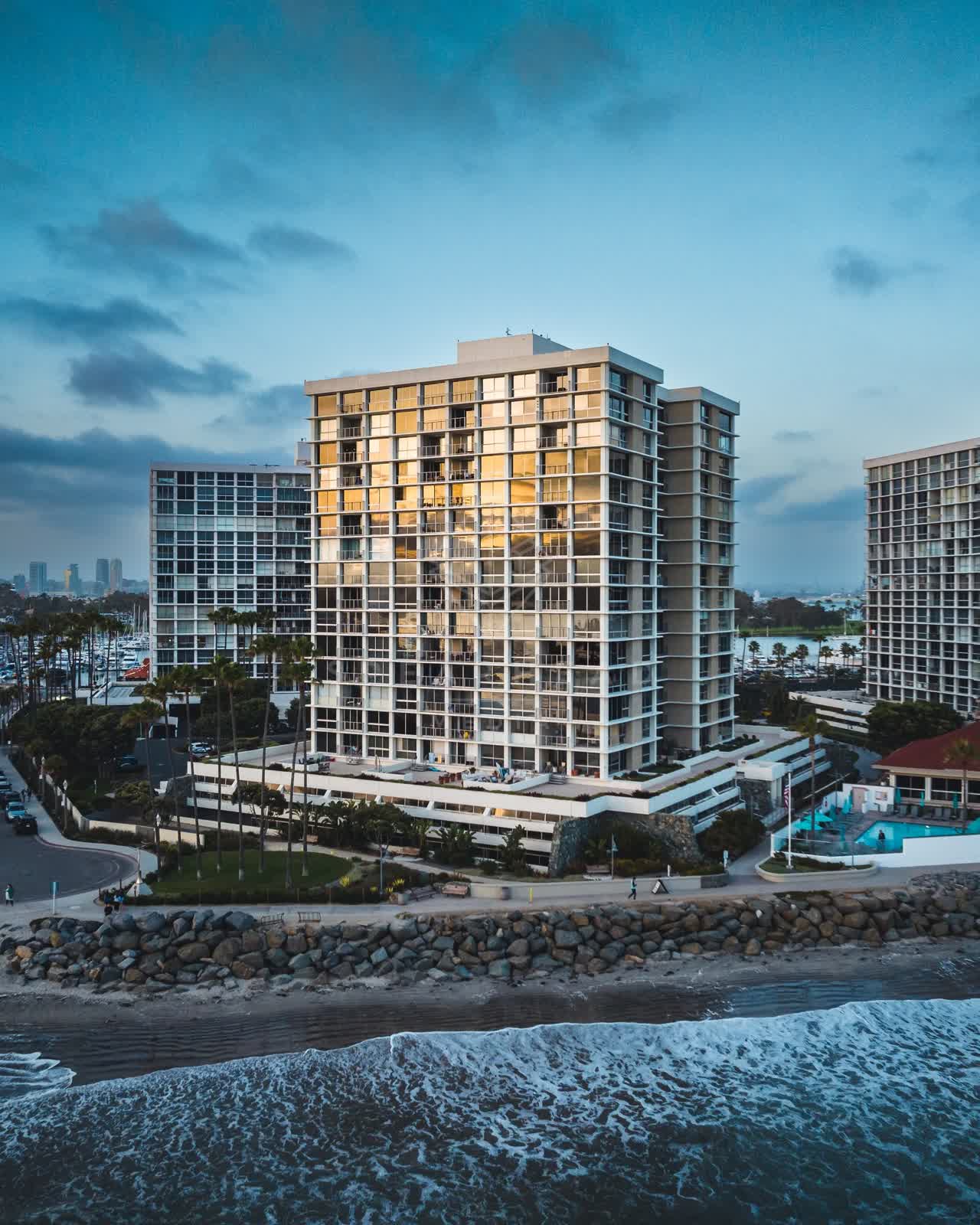 Low aerial view of the beach, boats and palm trees at Coronado Beach.
