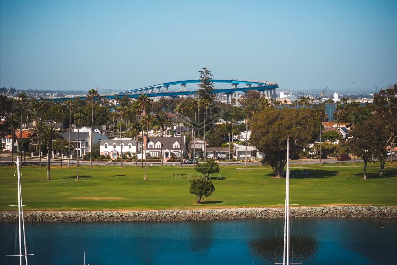 A residential street, the bridge and boats at Coronado Beach.