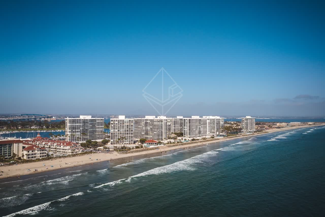 Aerial view of the beach, the surf and the bridge at Coronado Beach.