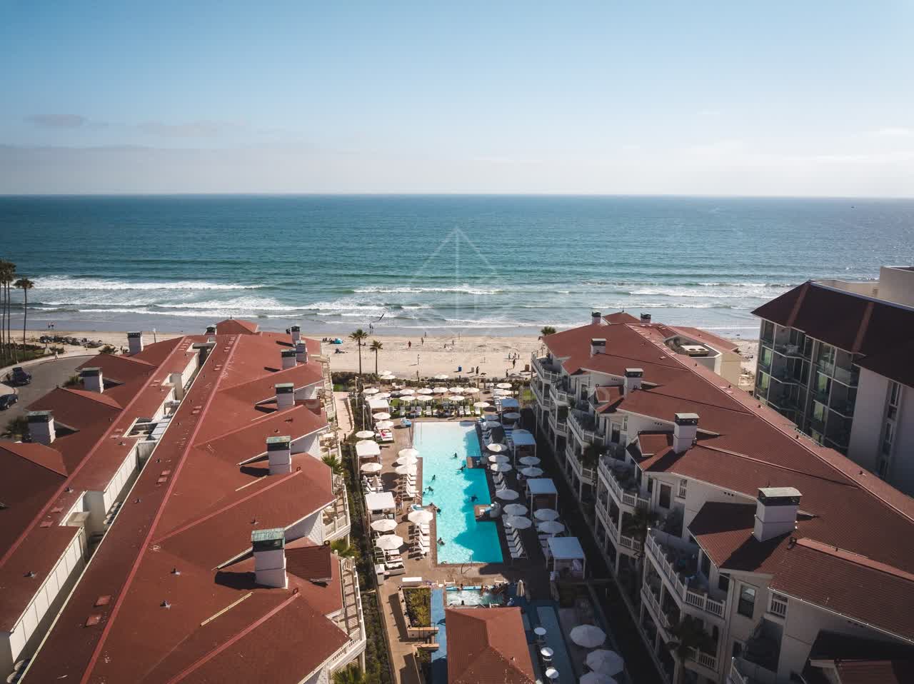 Aerial view of the beach, the surf and palm trees at Coronado Beach.