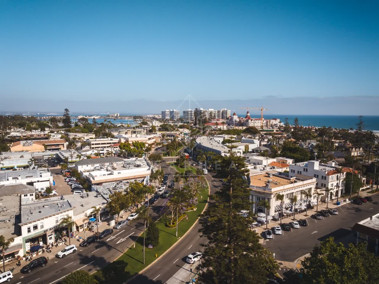 Aerial view of the downtown streets, the skyline and palm trees in Coronado, with people walking.
