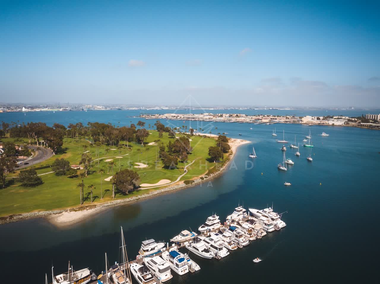 Aerial view of the harbor, boats and palm trees at Coronado Beach, with boats out.