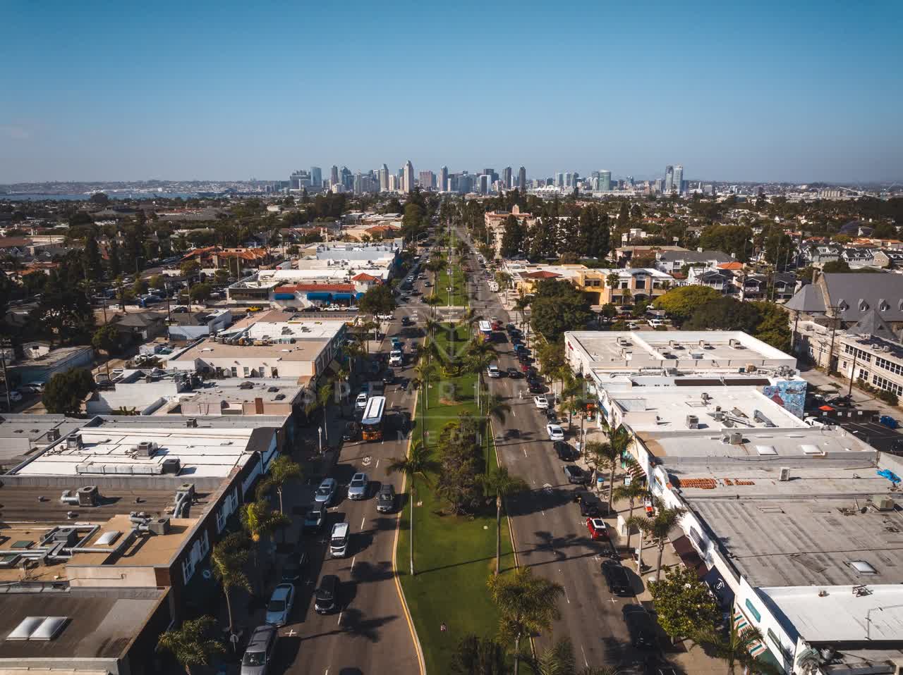 Aerial view of the downtown streets, the skyline and palm trees in Coronado, with people walking.