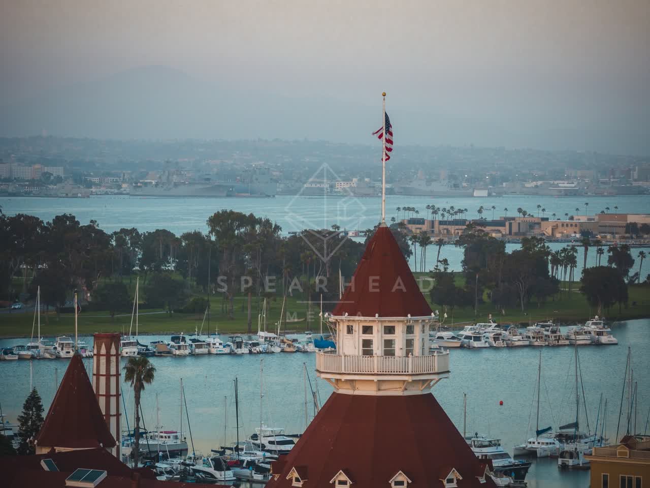 Low aerial view of the harbor, boats and palm trees at Coronado Beach, with boats out.