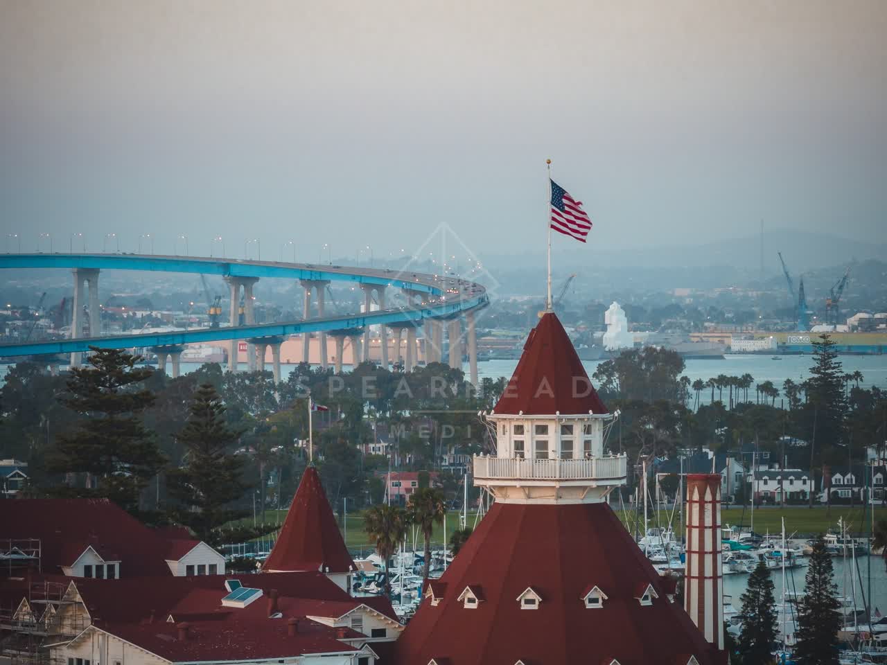 Low aerial view of the harbor, the bridge and boats at Coronado Beach.