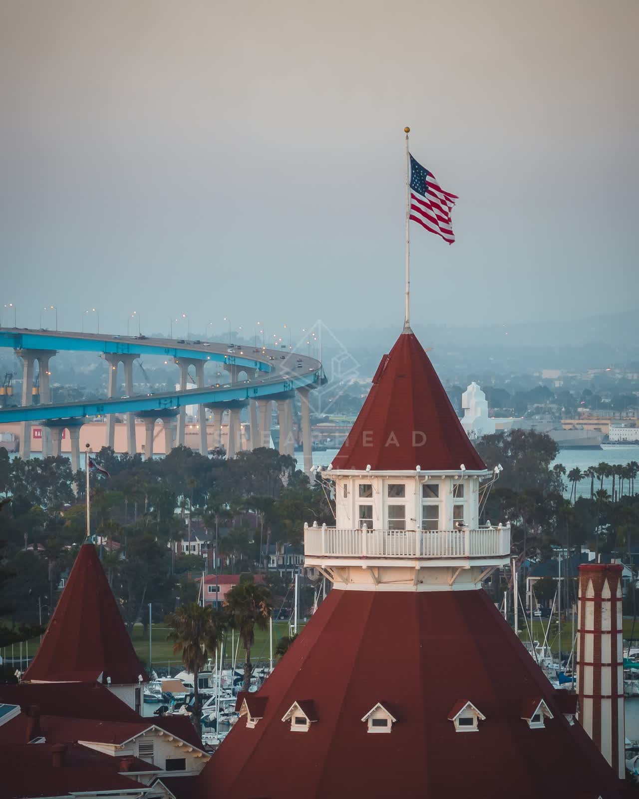 Low aerial view of the harbor, the bridge and boats at Coronado Beach.