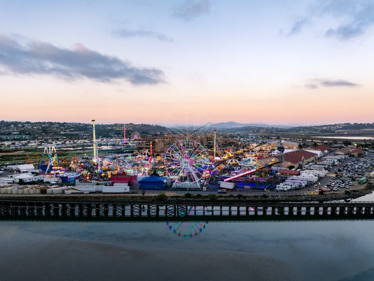 Aerial view of the country inland, traffic and open country in Del Mar, with a crowd gathered.