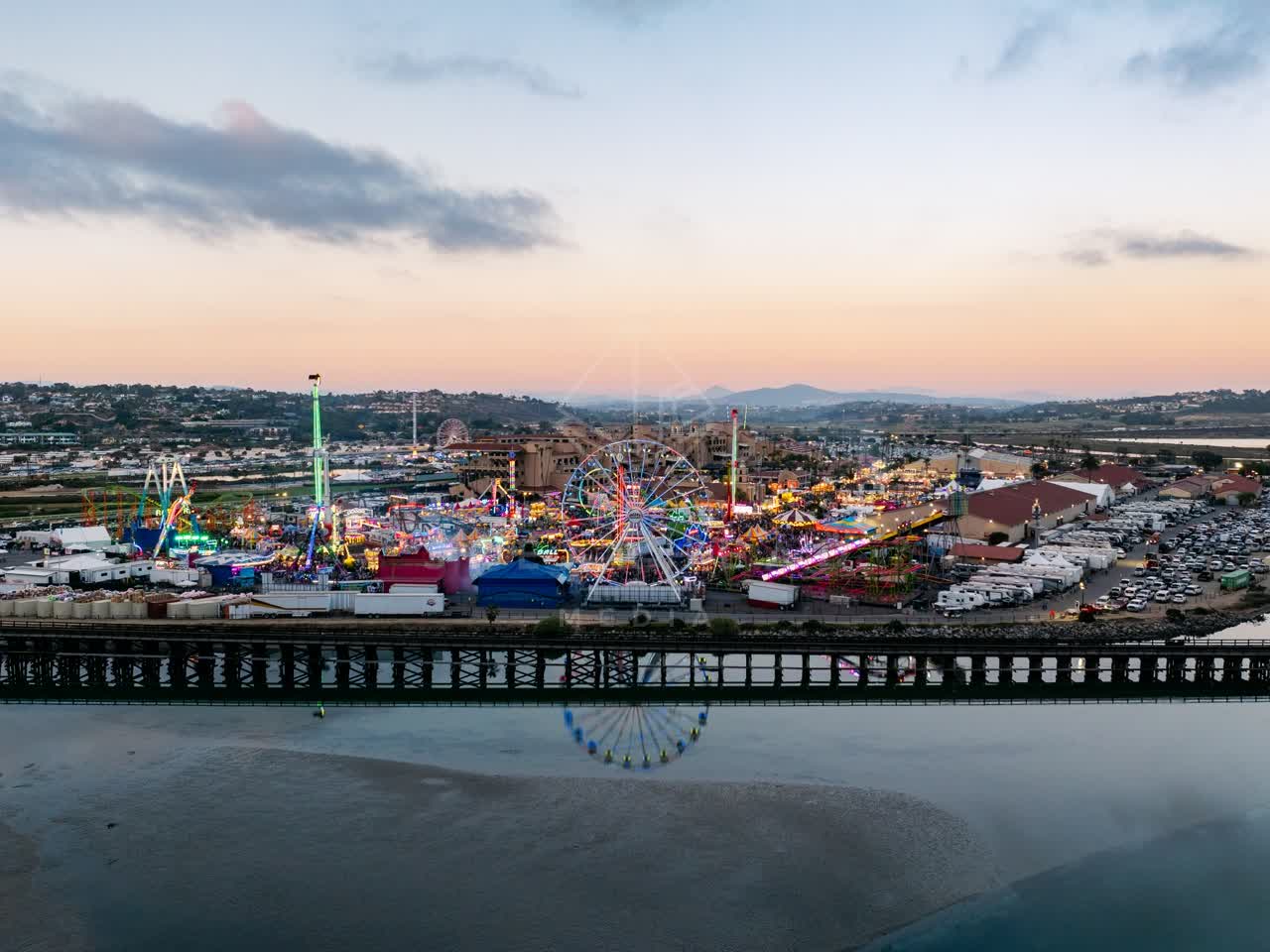 Aerial view of the country inland, traffic and open country in Del Mar, with a crowd gathered.