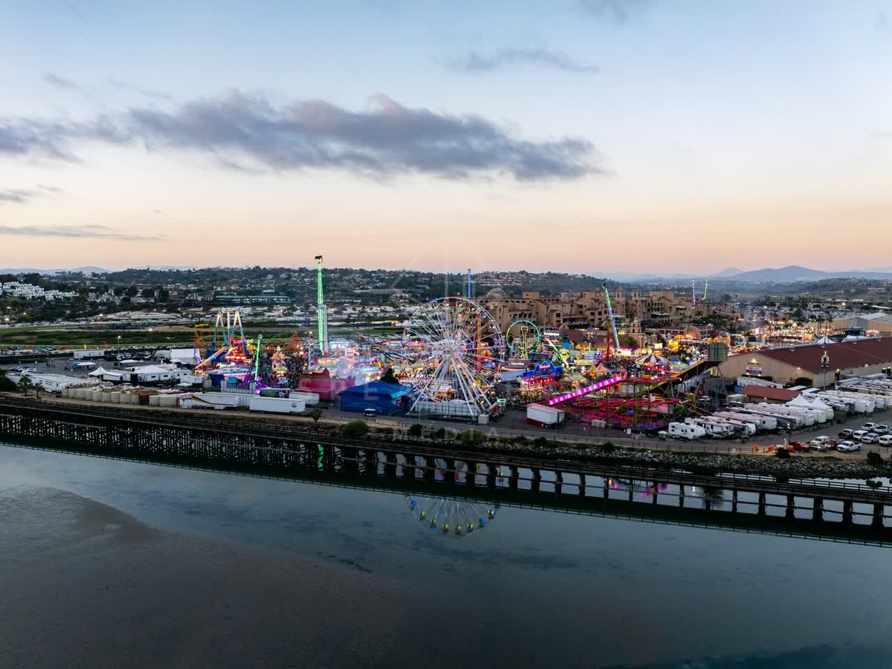 Aerial view of the country inland, traffic and open country in Del Mar, with a crowd gathered.