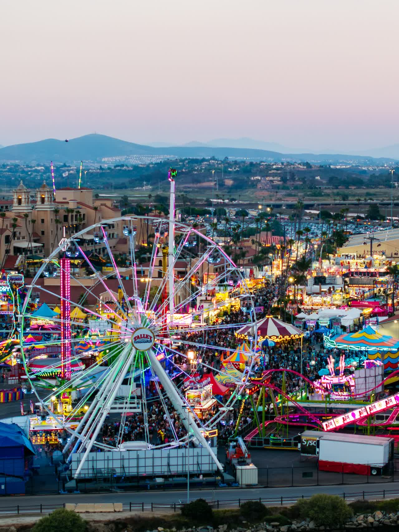 Aerial view of the country inland, the city and traffic in Del Mar, with a crowd gathered.
