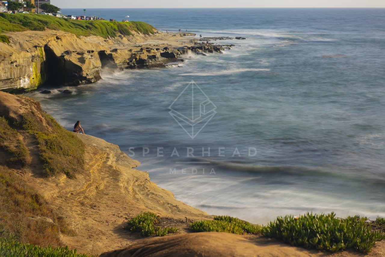 Elevated view of the cliffs, the surf and the ocean at La Jolla Cove.