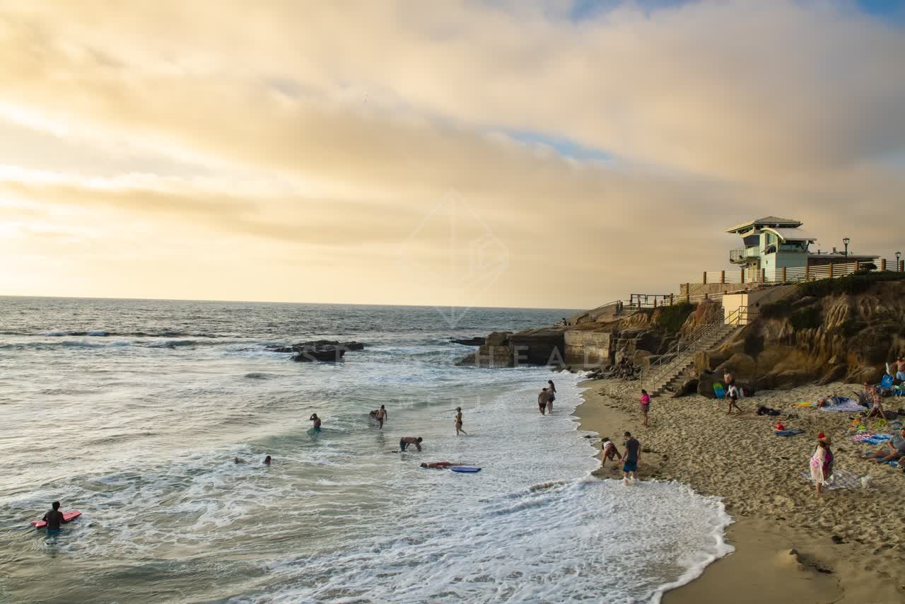 Elevated view of the beach, the surf and the ocean at La Jolla Cove, with swimmers in the water.