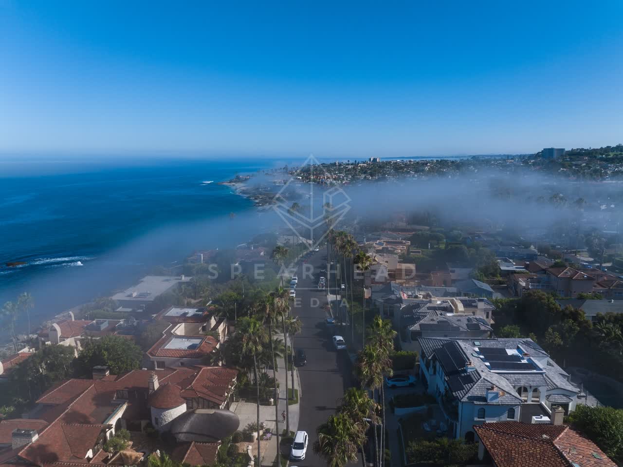 Aerial view of a residential street, palm trees and the ocean at Lower Hermosa.