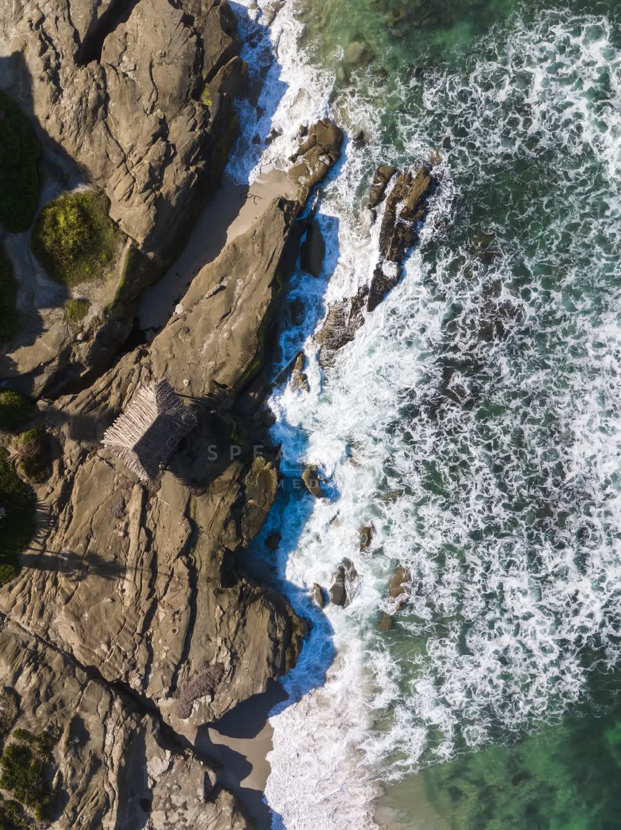 Aerial view of the cliffs, the surf and the ocean at Windansea.