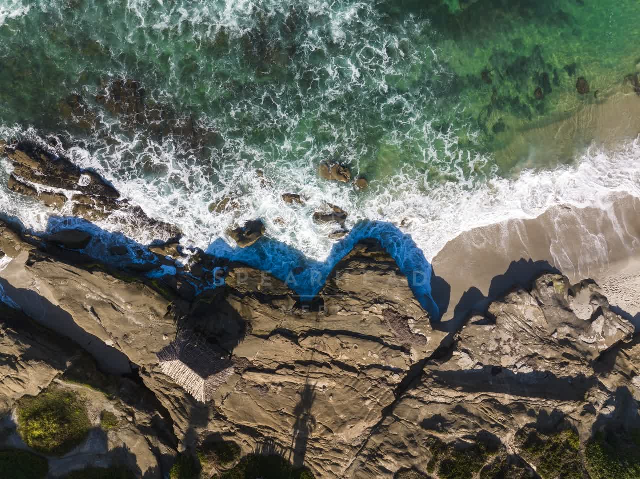 Aerial view of the cliffs, the surf and the ocean at Windansea.