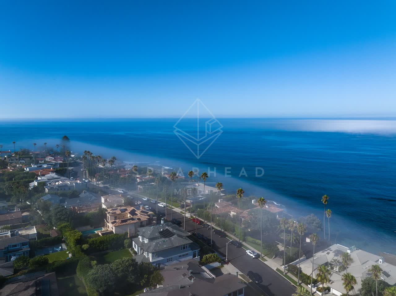 Aerial view of a residential street, palm trees and the ocean at Lower Hermosa.