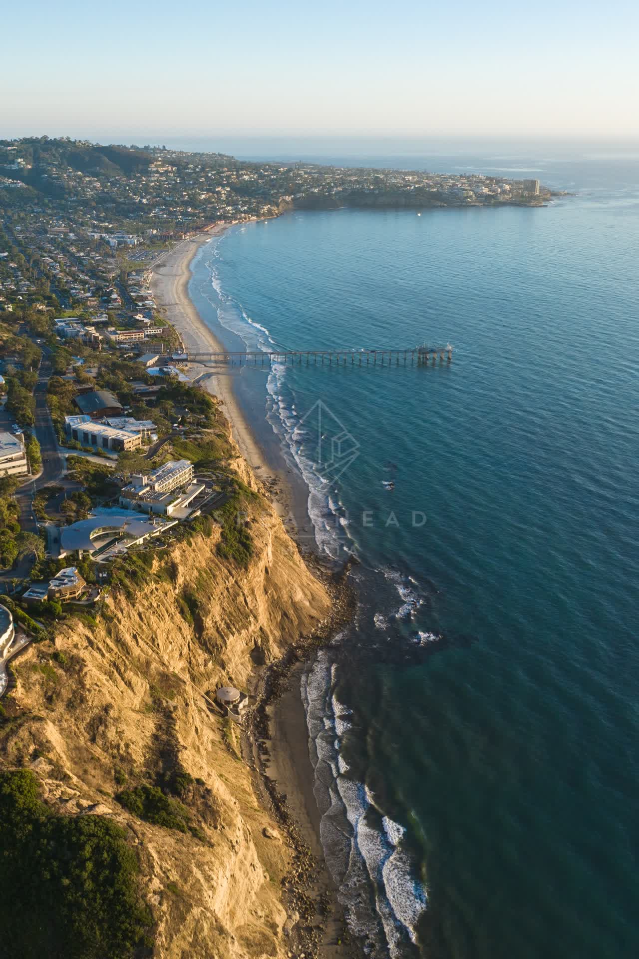 Aerial view of the cliffs, the pier and the ocean at La Jolla Shores.