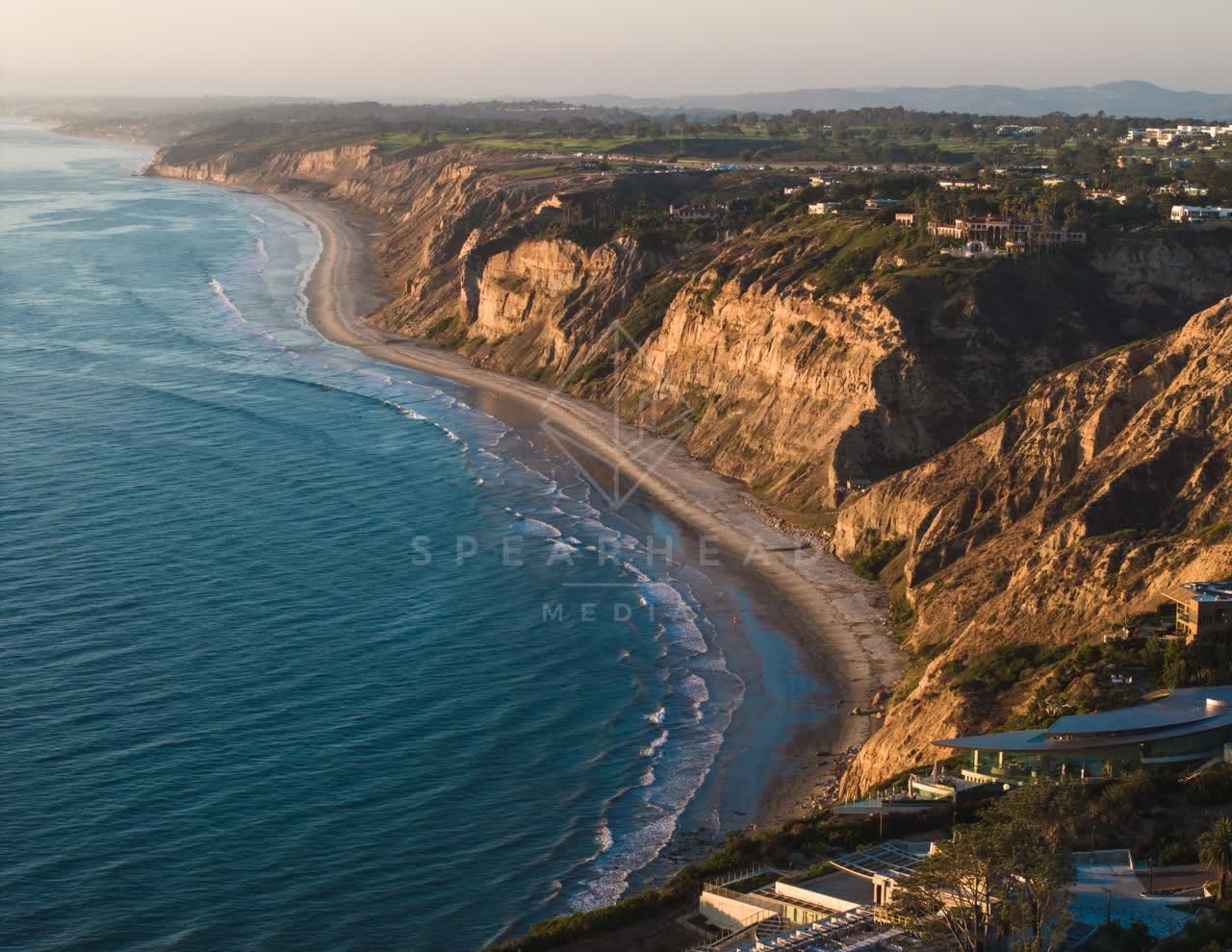 Aerial view of the cliffs, the surf and the ocean at Black’s Beach.