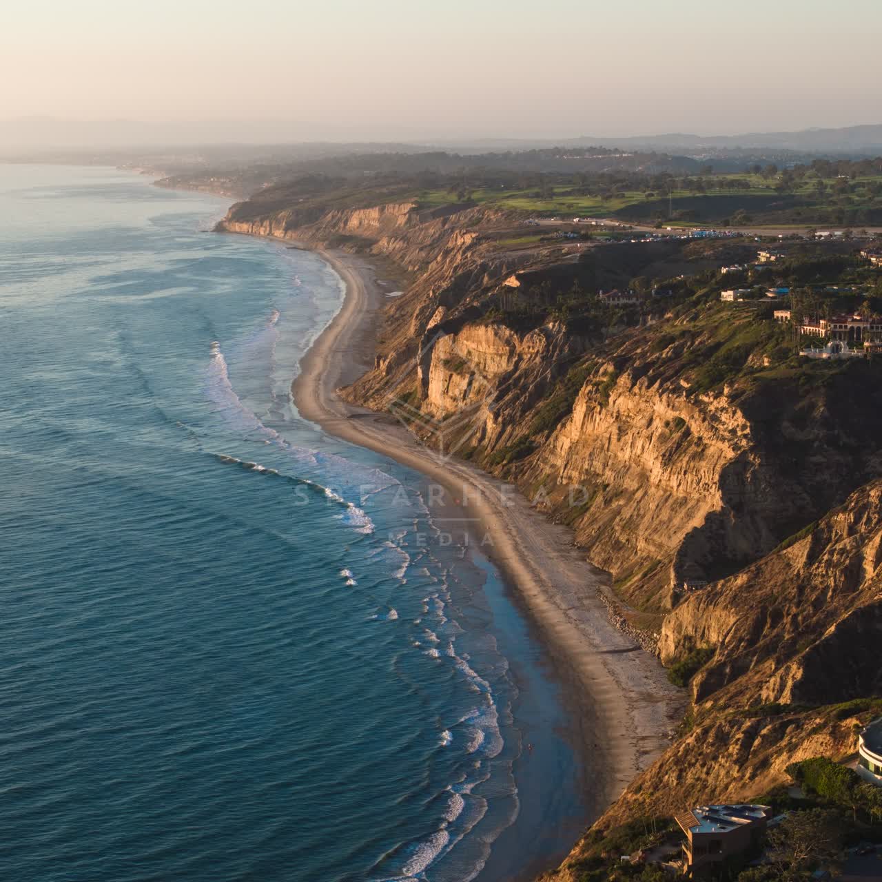 Aerial view of the cliffs, the surf and the ocean at Black’s Beach.