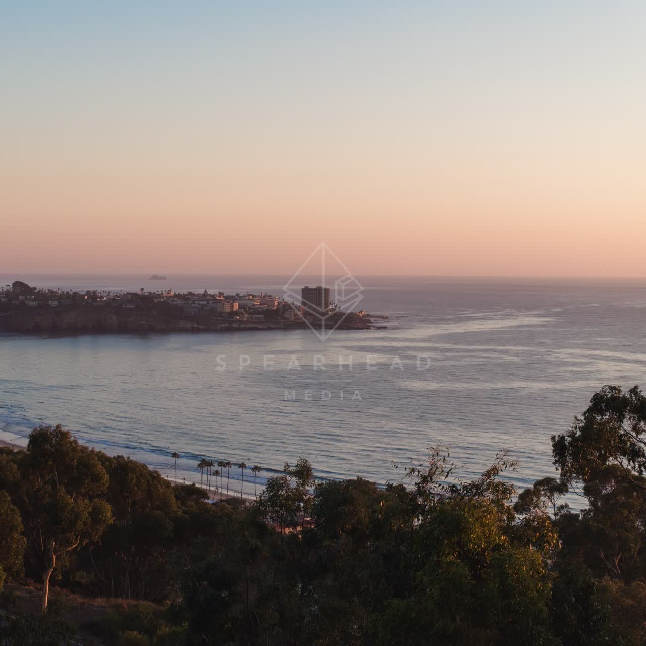 Elevated view of the cliffs, palm trees and the ocean at La Jolla Shores.